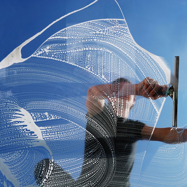 man cleaning large window